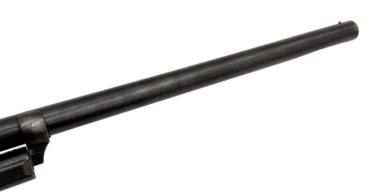 Remington Model 10 12 gauge pump-action shotgun with wooden stock and metal barrel, shown from side view.