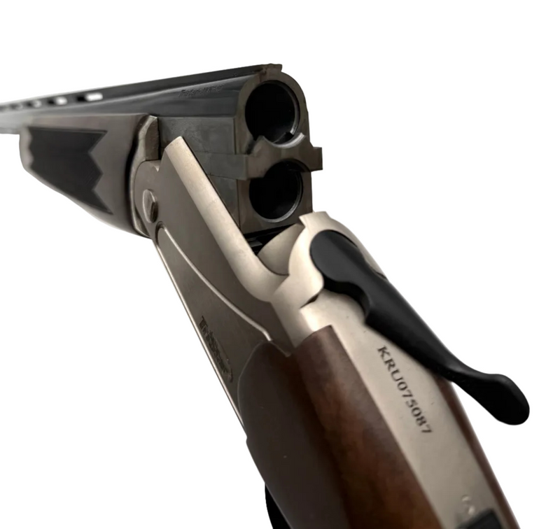 TriStar Upland Hunter 20 Gauge over-under shotgun with wooden stock and metal barrel, displayed in a natural outdoor setting.